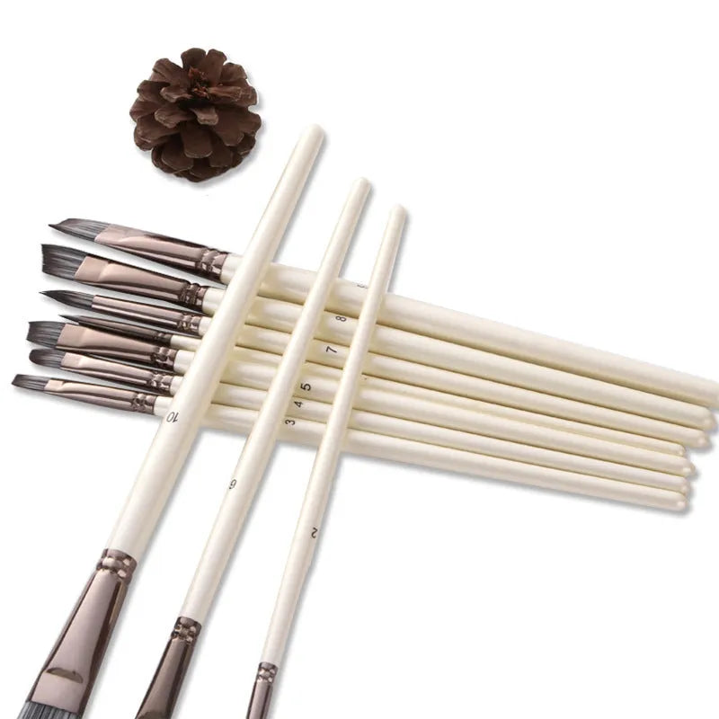 Set of ten pearl white nylon watercolour brushes with wood handles on a table.