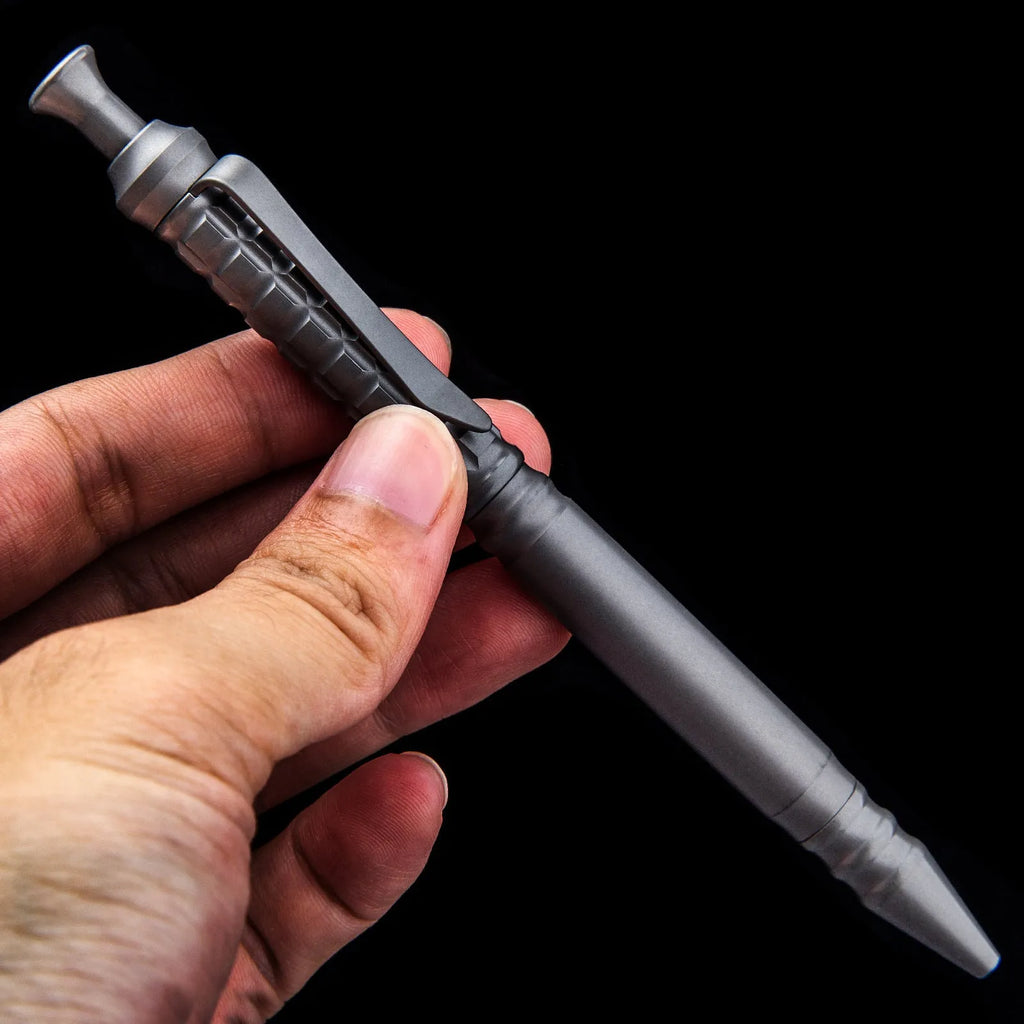 Gunmetal grey titanium alloy tactical pen with push-action mechanism and 0.5mm nib in a gift box.