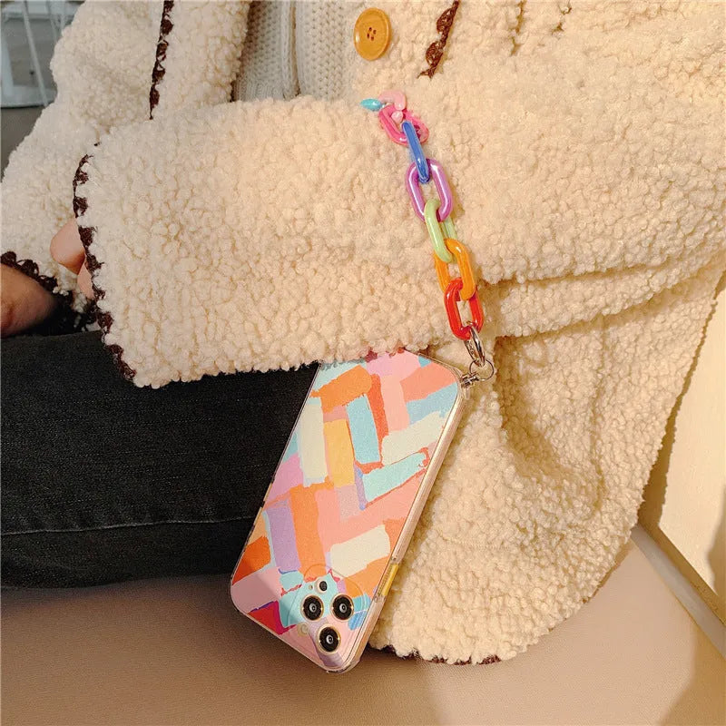 Graffiti design mobile phone case with bracelet strap attached, shown fitting iPhone model