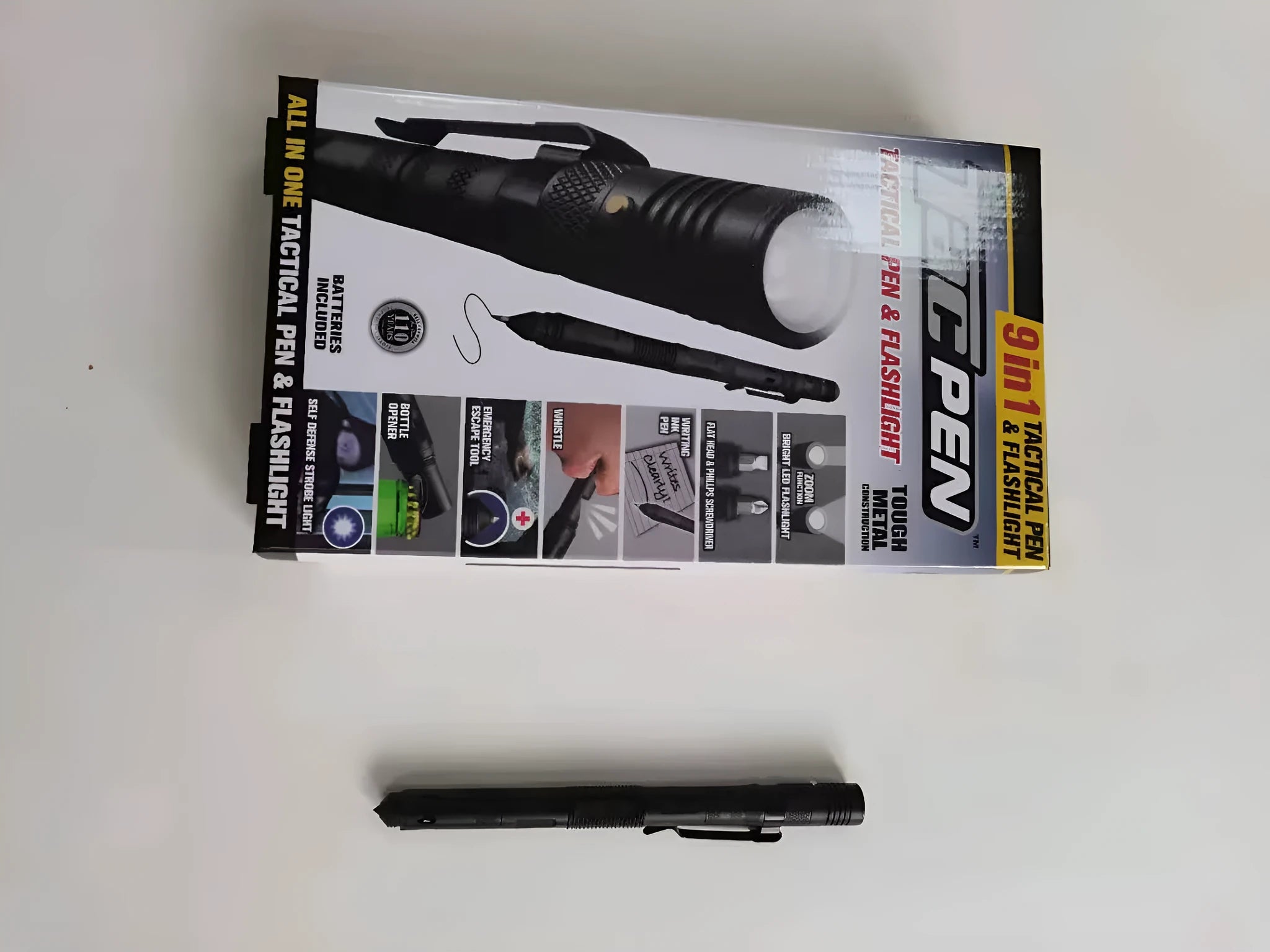 Black multi-function survival pen with built-in LED flashlight and pointed steel window breaker tip.