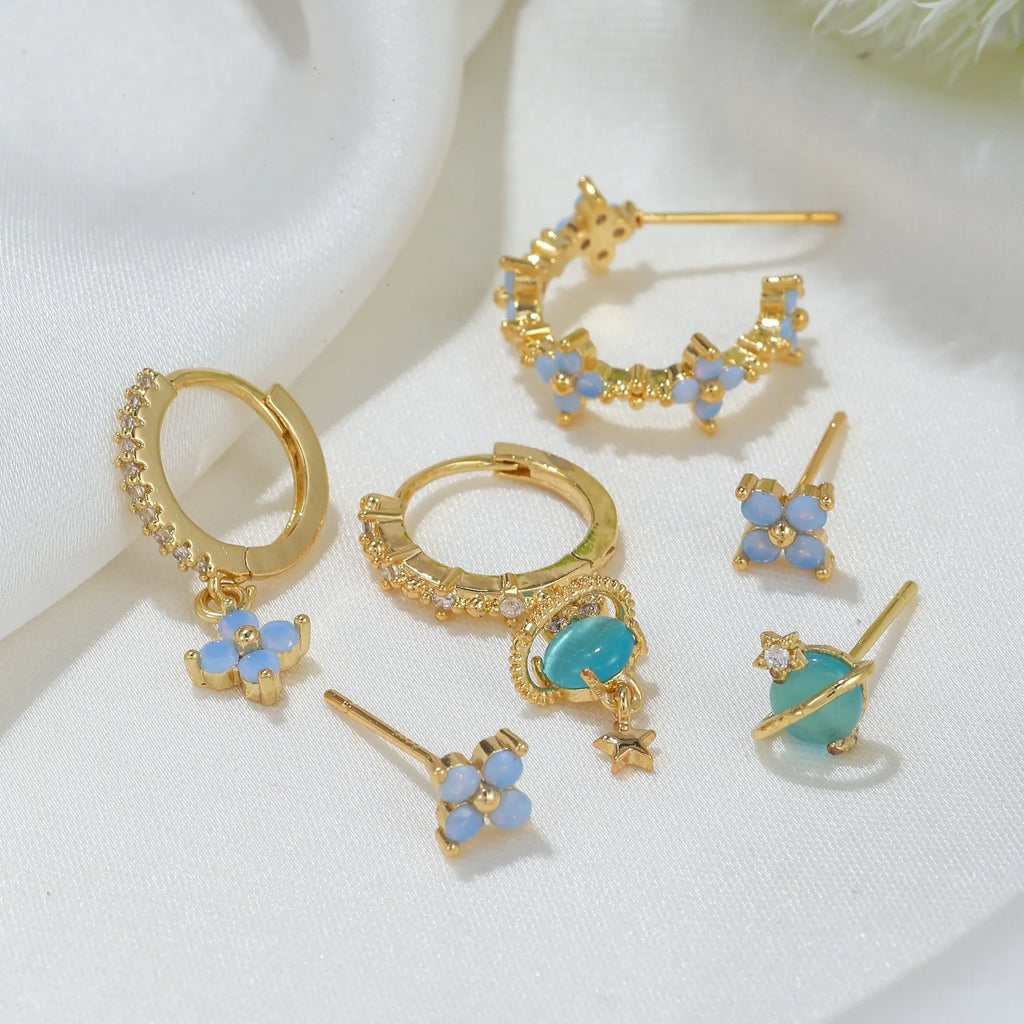 Gold and silver Japanese Korean style ear studs with blue flower nail design and zircon detail