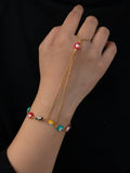 Women's titanium steel round eyes lucky mitten-type bracelet in colourful electroplated finish on a neutral background
