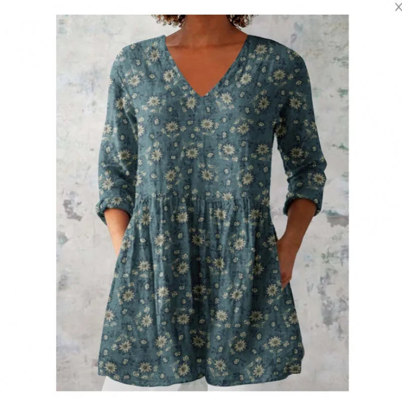 A woman wearing a loose-fitting floral print dress with 3/4 ruffle sleeves and a wide waist.