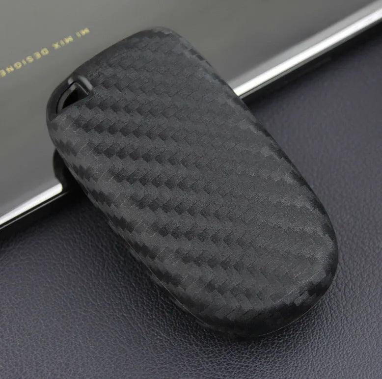 Black silicone protective case covering a Dodge car key fob, shown next to an unbuckled version.