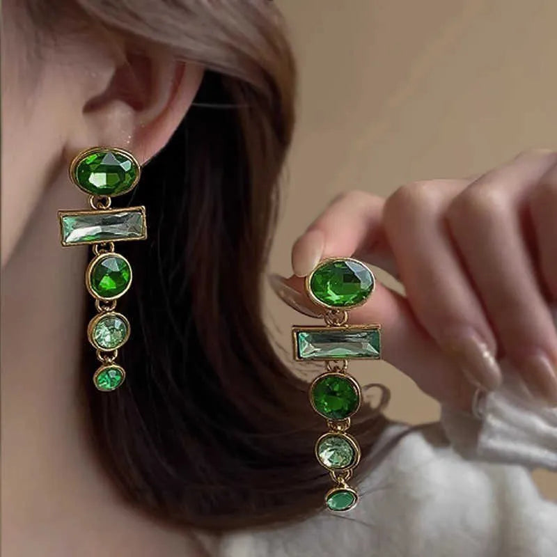 Green gradient tassel drop earrings with geometric alloy shapes and inlaid zircon stones on a white background.