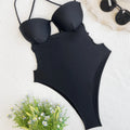 Women's solid black one-piece swimsuit on a hanger