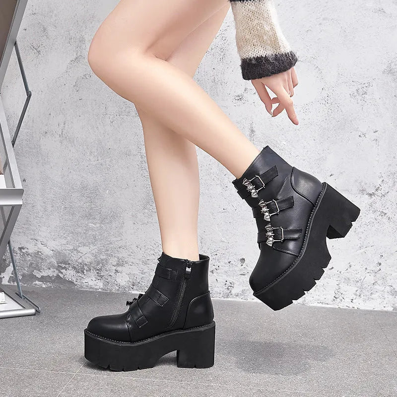 Black women's ankle boots with bat buckle, side zip, and thick heel.