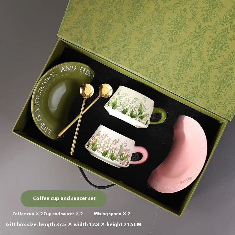 Ceramic coffee cup and saucer set for couples with two cups, saucers, and spoons.