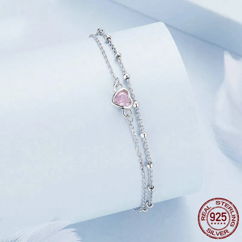 Silver heart-shaped charm bracelet for women on an adjustable chain.