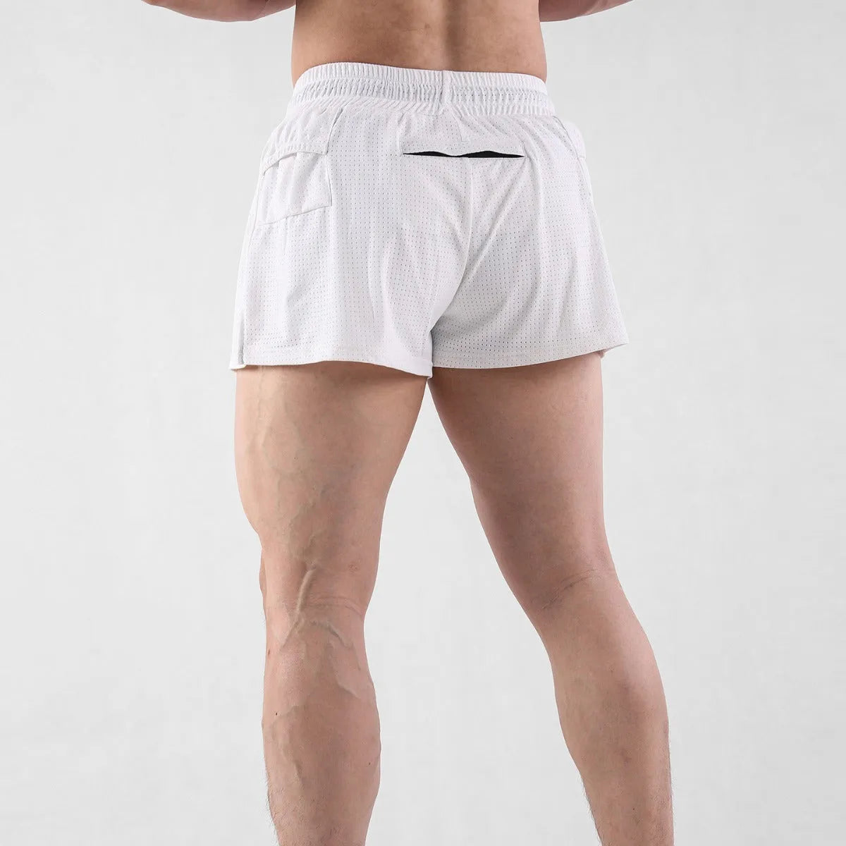 Man wearing black quick-dry nylon summer shorts on a light background