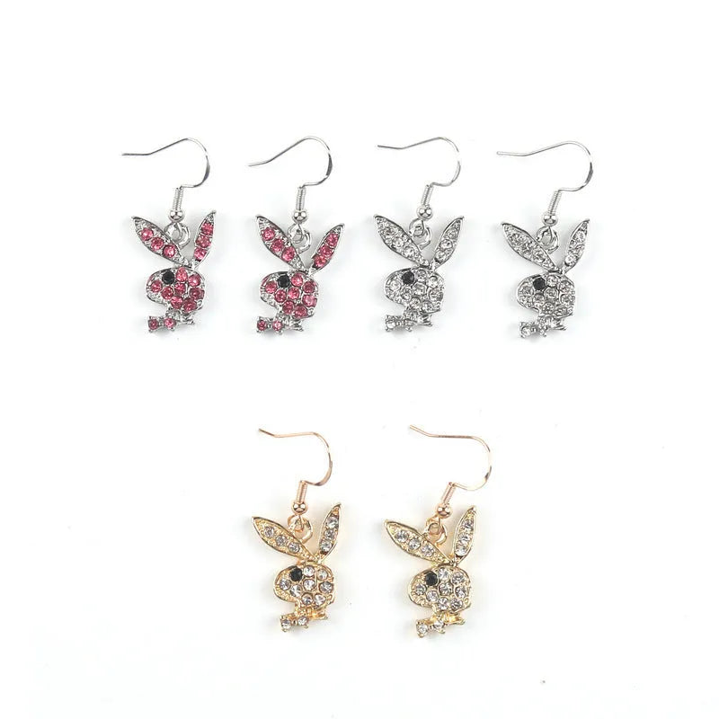 Close-up of a pair of small silver rabbit stud earrings with a sparkling rhinestone set in the centre on a white background.