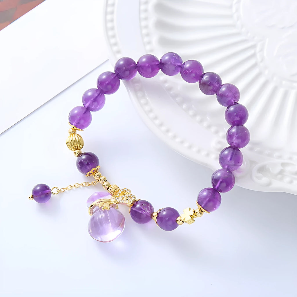 Purple amethyst crystal bracelet with money bag pendant and geometric peace buckle on wrist