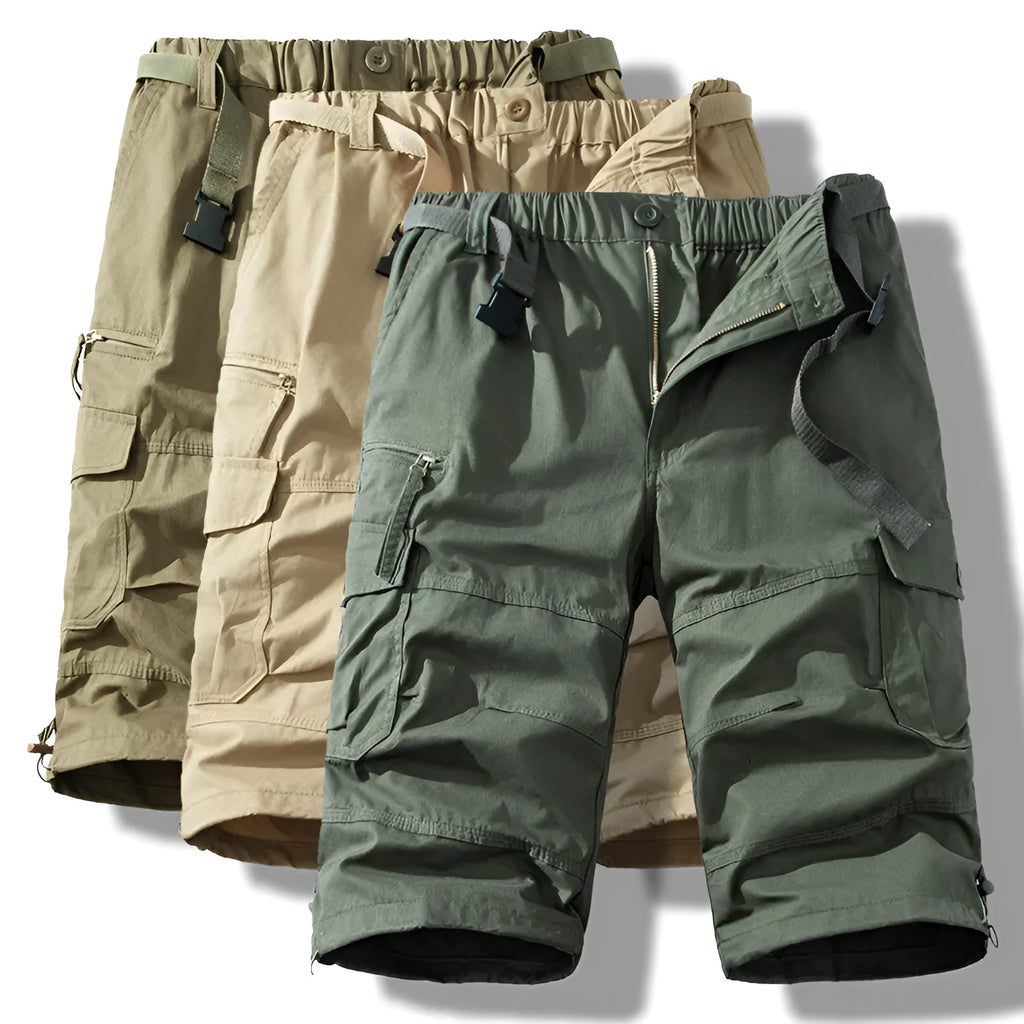 Men's cotton cropped overalls in army green, shown in a casual summer setting.
