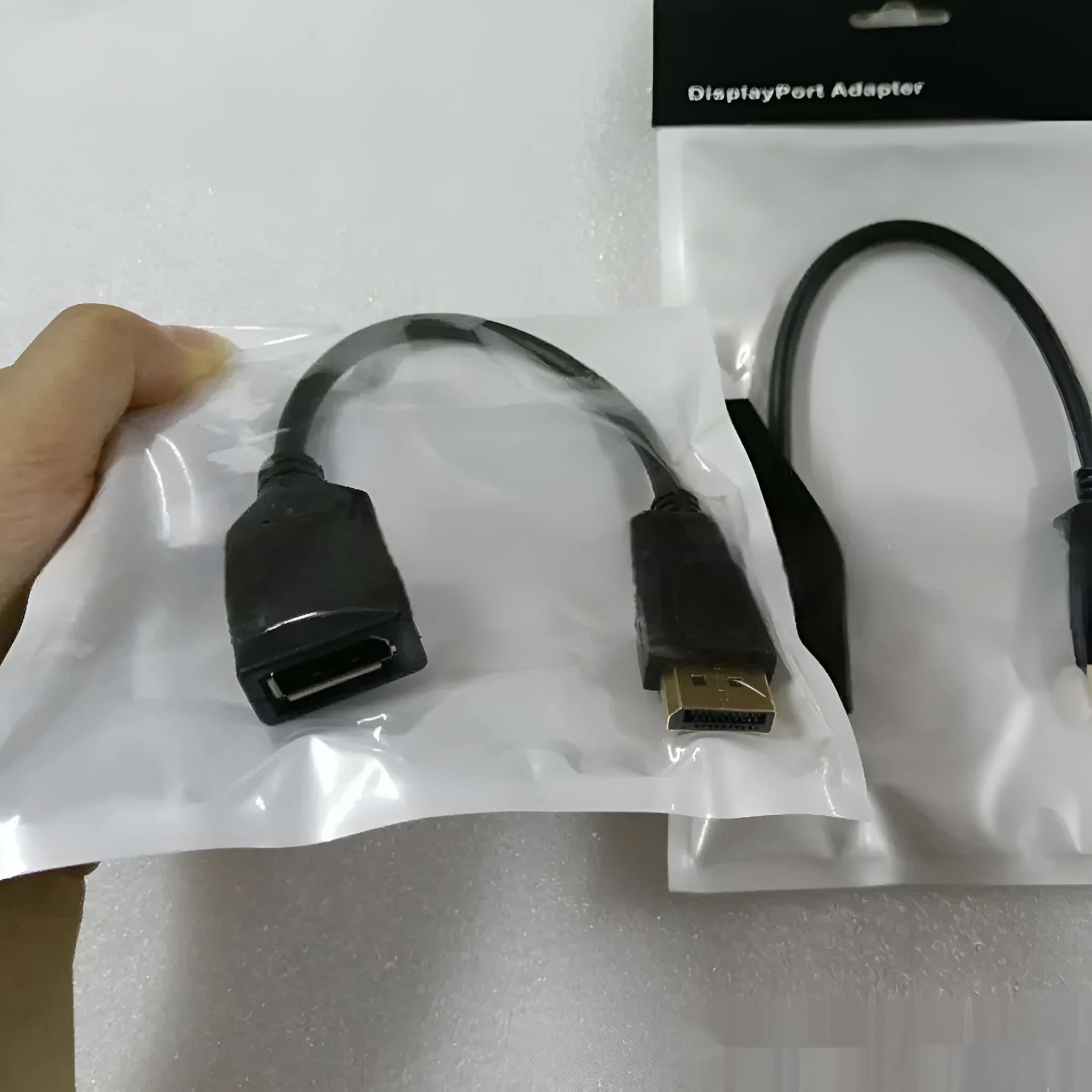 Black DisplayPort DP male to female extension cable with rotating connector, approximately 10cm length