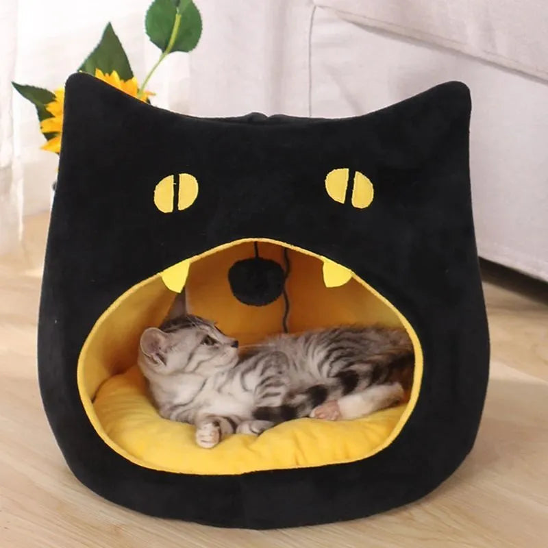 Grey cat-shaped enclosed pet bed with a round opening, sitting on a wooden floor.
