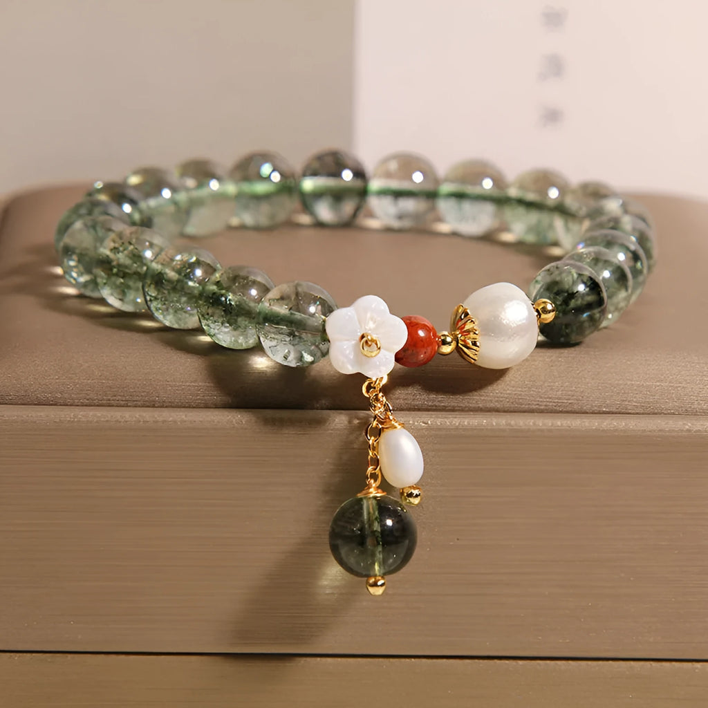 Green phantom quartz crystal bracelet for women with small shell flower and Bells of Ireland design details.