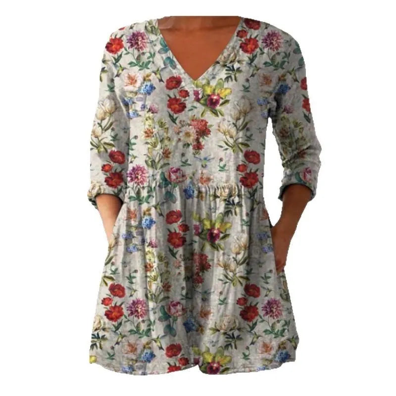 A woman wearing a loose-fitting floral print dress with 3/4 ruffle sleeves and a wide waist.