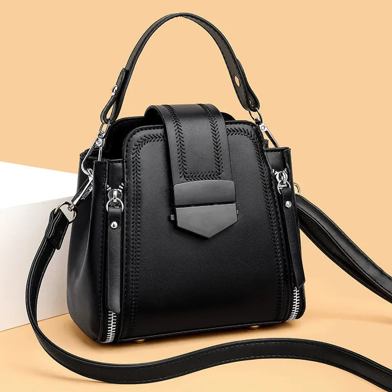 Small square vertical ladies handbag in soft textured PU leather, showing sewing thread detail.