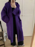 Loose-fitting beige hooded cardigan coat for women with raglan sleeves on a hanger.