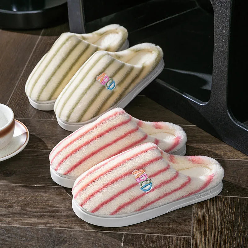 A pair of soft cotton adult slippers with a plastic sole, shown in one of five colour options.