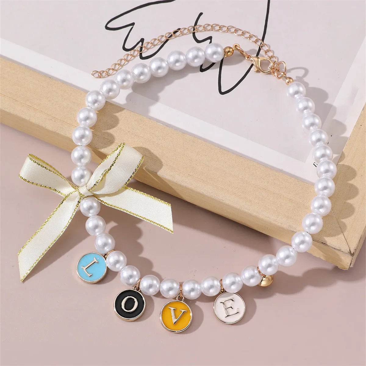 Cartoon pattern monochrome pet pendant necklace on a white background – pearl-like material, black colour option