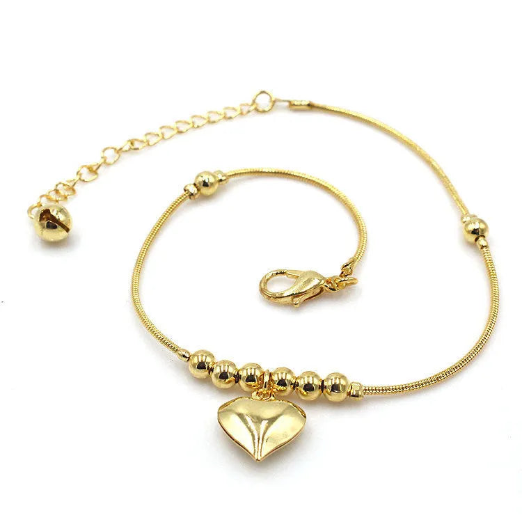 Gold colour gothic heart pendant anklet on a woman's ankle with chunky ball beads and copper chain 27cm
