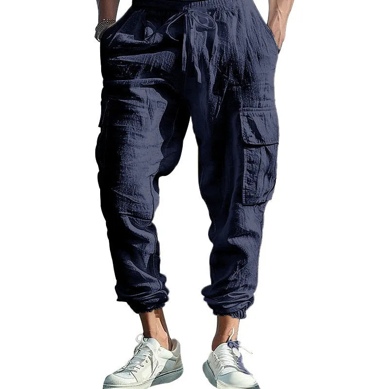 Man wearing loose-fit khaki linen casual trousers with ankle ties and multiple pockets.