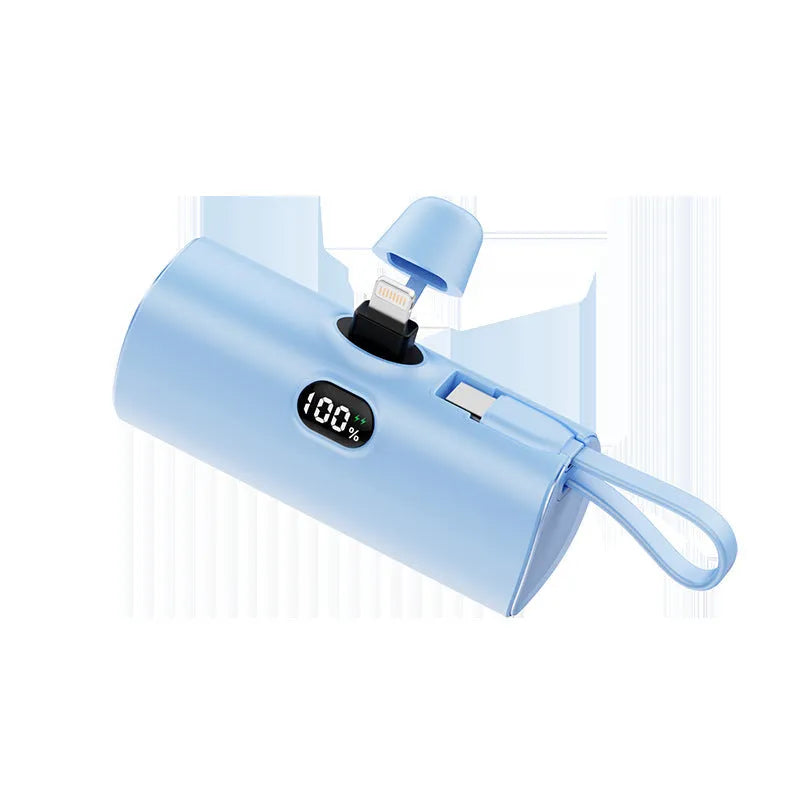 Compact capsule-shaped wireless power bank with digital display and integrated plug, shown in multiple colours.