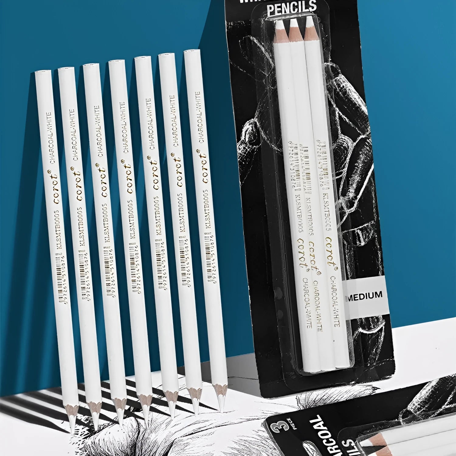 Three white charcoal sketching pencils with wooden barrels in a set.