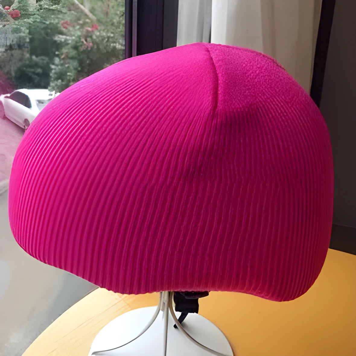 White snow helmet decorative cover with matching beanie hat laid flat on a blue background.
