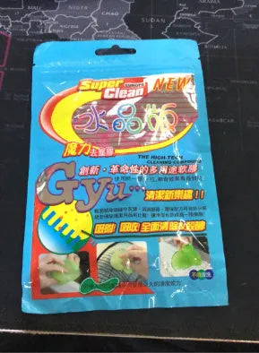 Blue and yellow lumps of Magic Cleaning Gel adhesive putty for dust removal, shown with a car vent and keyboard.