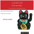 Small yellow solar powered Maneki Neko lucky cat decoration waving its arm.