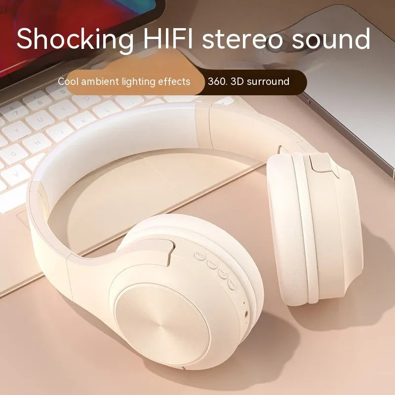 Over-ear wireless Bluetooth headset in Ivory White with a matching charging case on a table.
