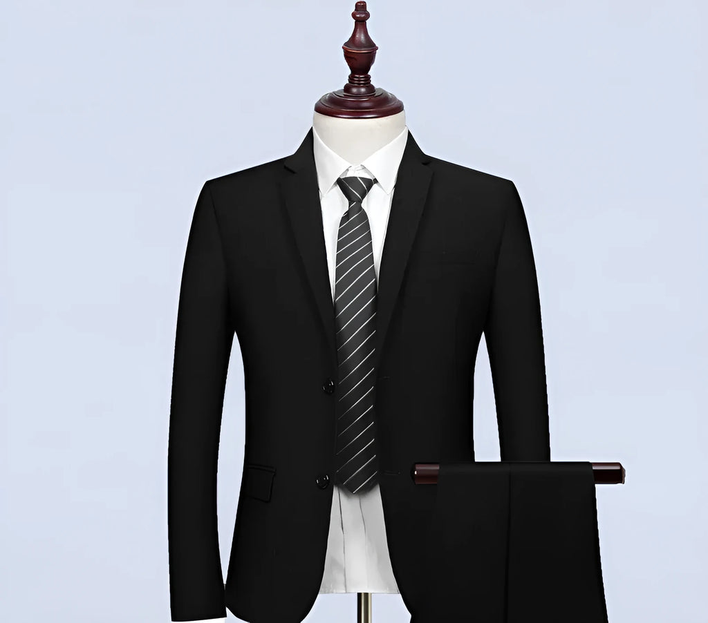 New men's slim fit black business suit set with 1-button jacket, waistcoat, shirt, and trousers on a hanger.