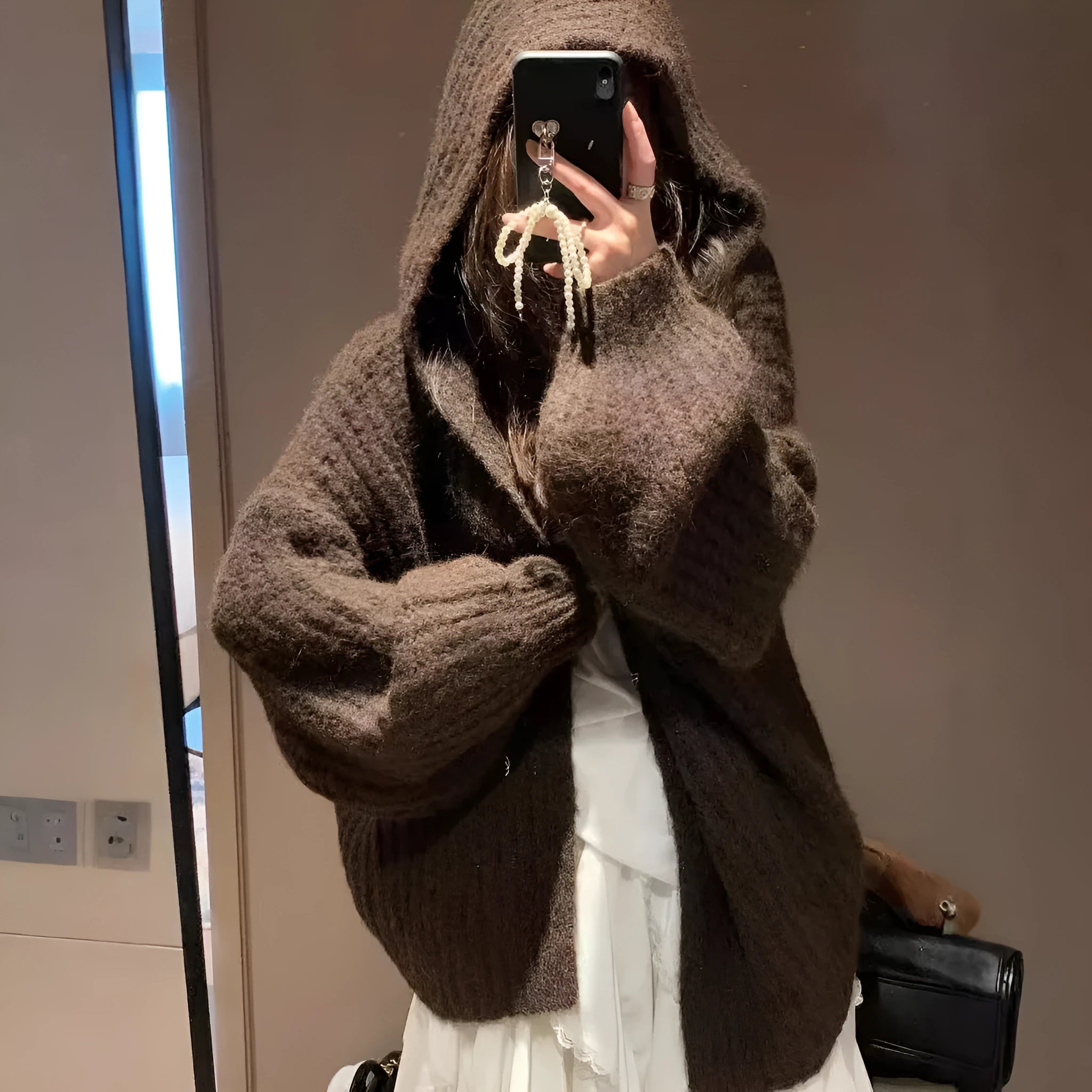 A woman's loose-fitting, hooded sweater cardigan in a solid colour, shown with regular sleeves.