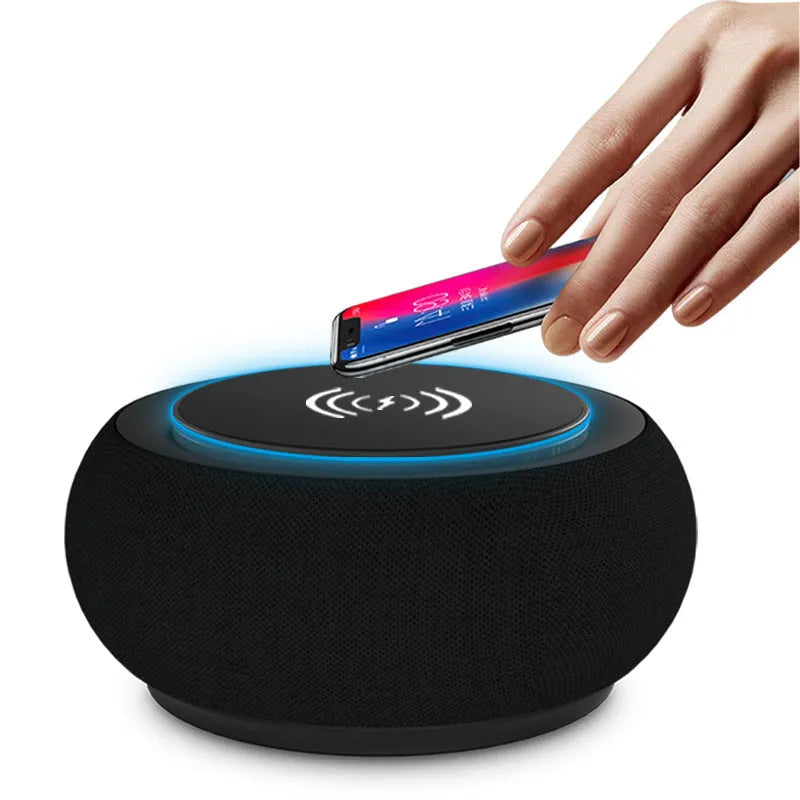 Black wireless Bluetooth speaker with dual speakers and subwoofer on a wooden table