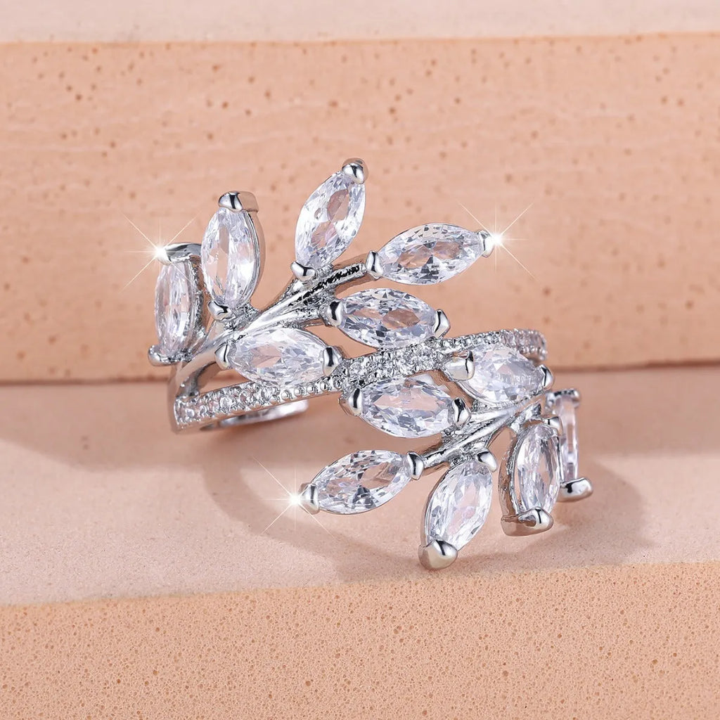 Adjustable copper leaf-shaped ring with sparkling zircon stones in rose gold and platinum finishes.