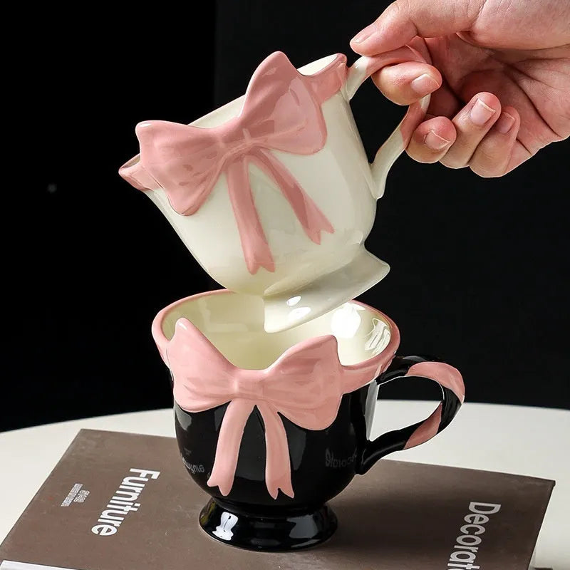Ceramic mug with heart bow design in white powder and black pink colours.