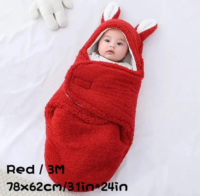 Baby wearing a grey adjustable fleece swaddle sleep sack with velcro wings