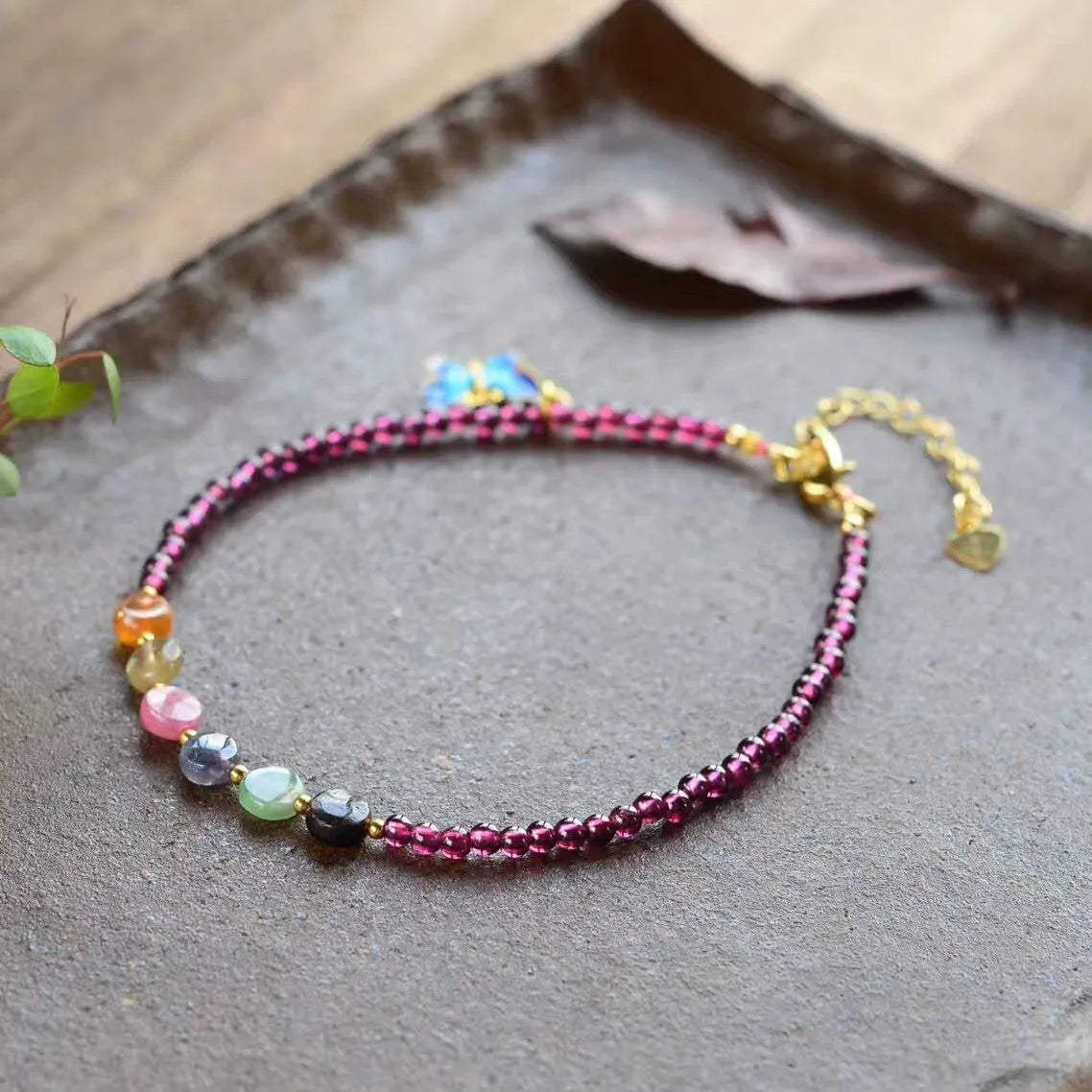 Close-up of a purple garnet anklet with a geometric design on a female ankle.