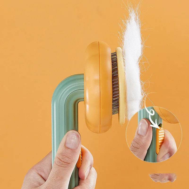 Pumpkin-coloured hand-held pet brush with curved stainless steel teeth for grooming cats and dogs