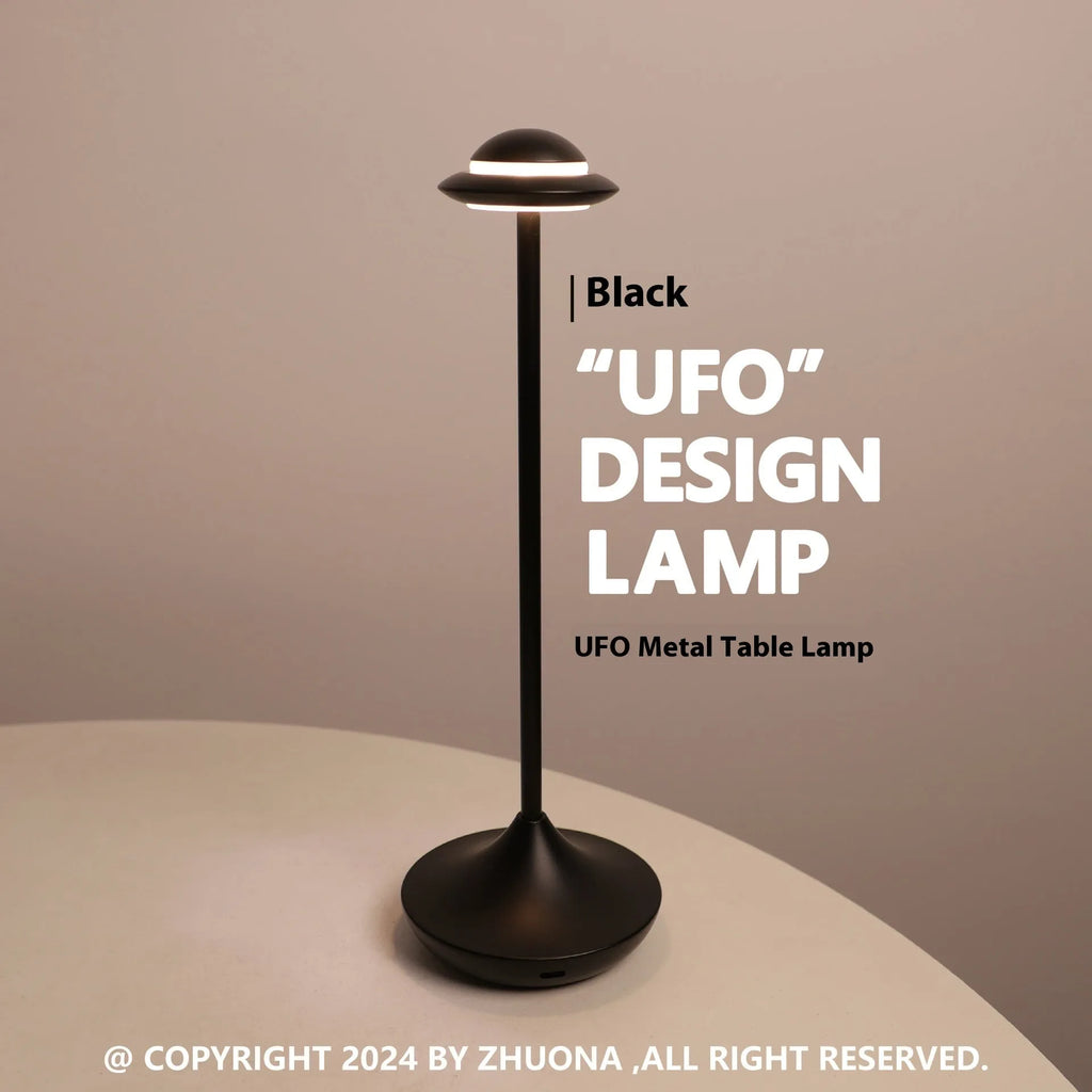 Modern gold UFO-shaped metal desk lamp with touch-sensitive base on a wooden table.