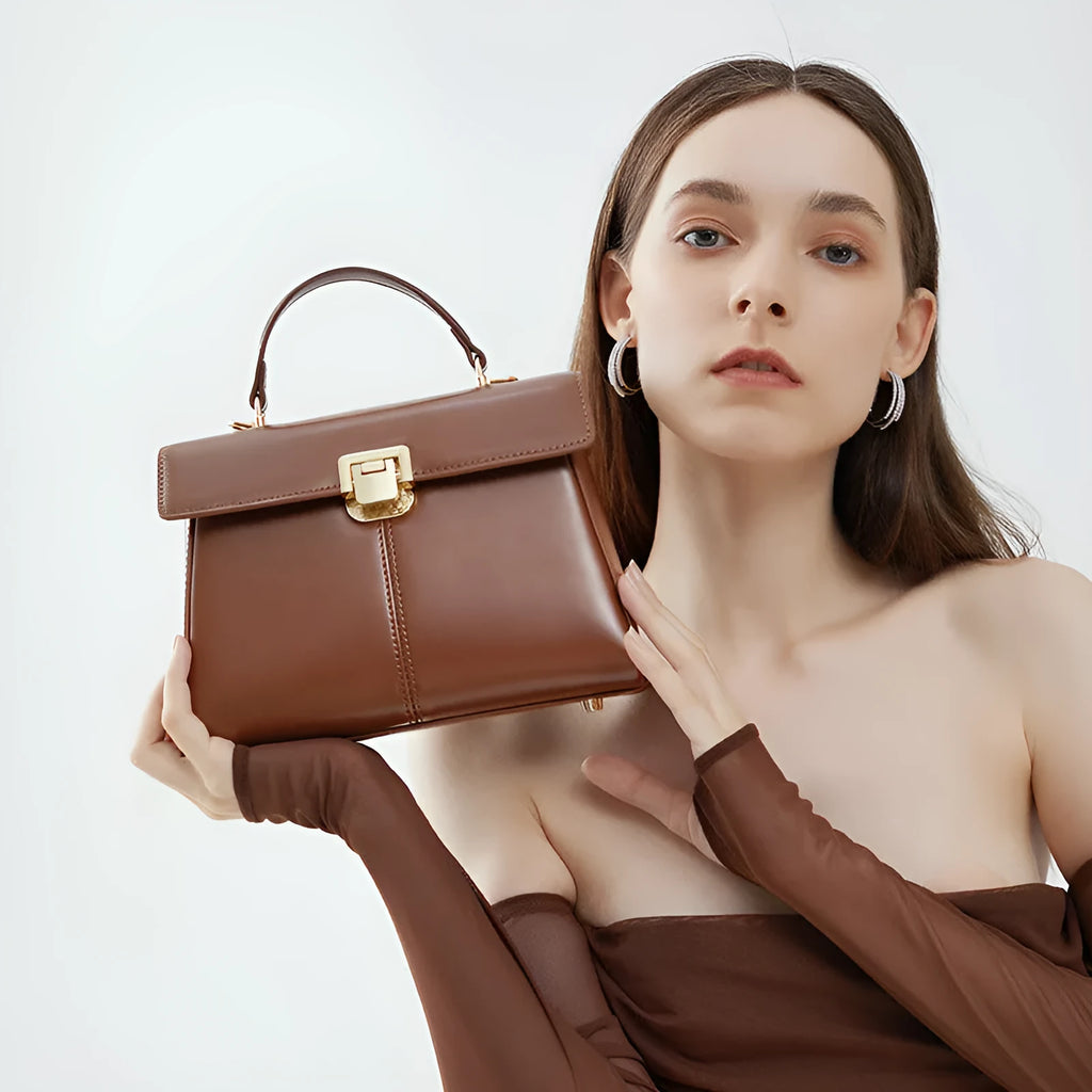 Women's black genuine vachette leather shoulder bag with clasp closure and 120cm strap.