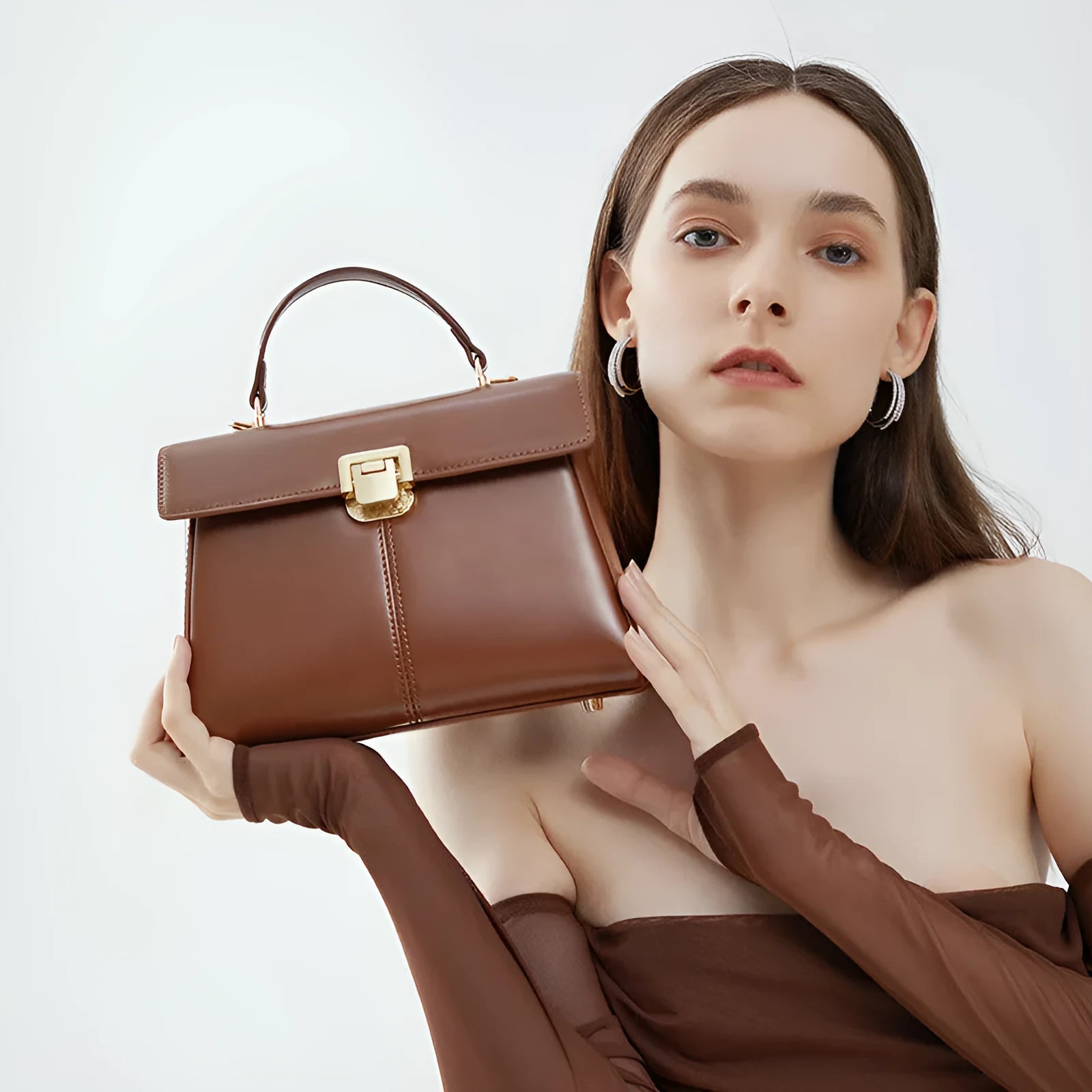 Women's black genuine vachette leather shoulder bag with clasp closure and 120cm strap.