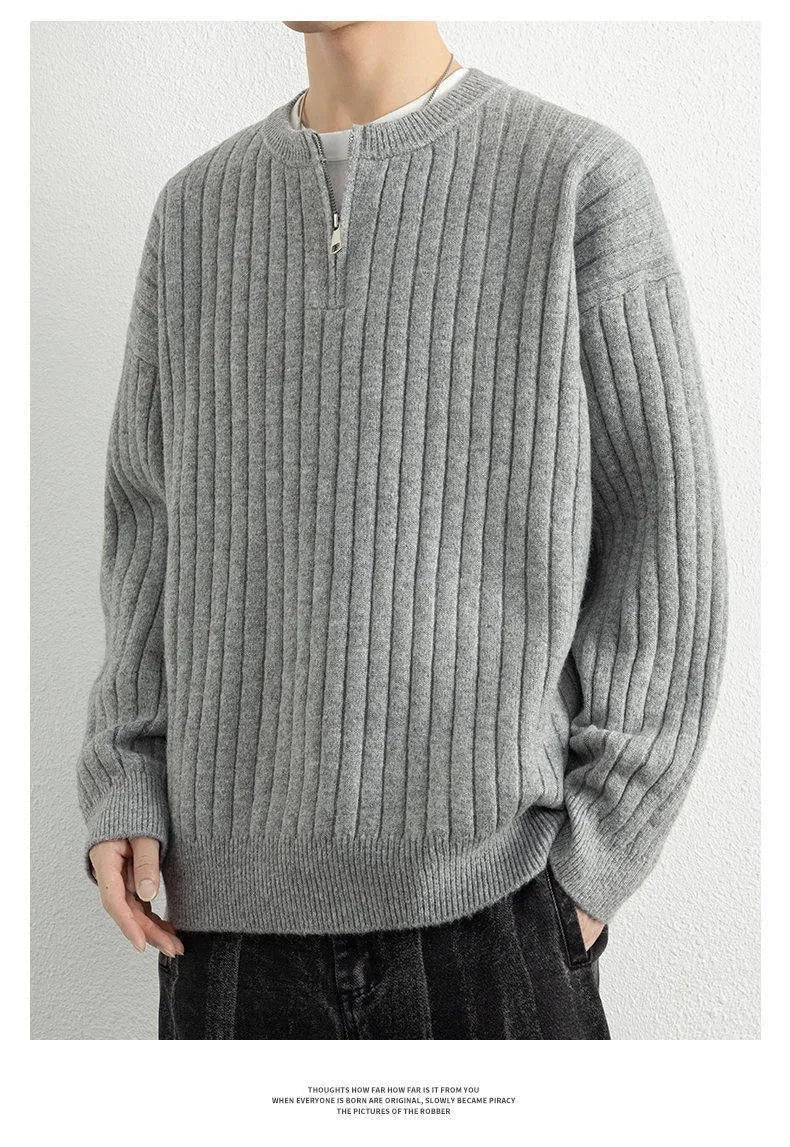A grey men's loose fit half zip sweater with a textured knit and long sleeves on a plain background.