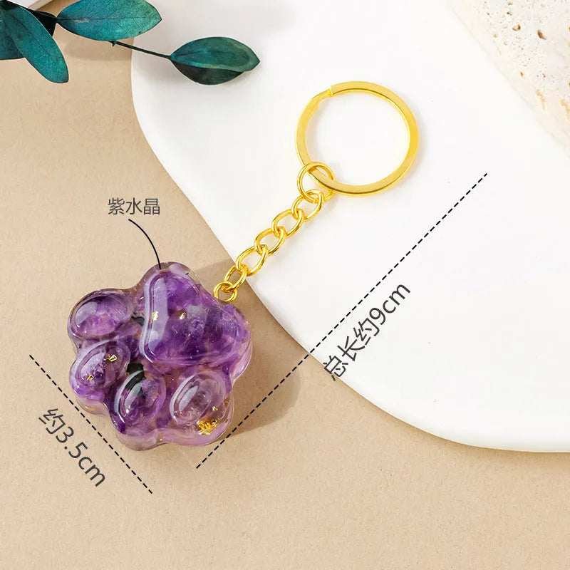 Natural crystal cat's paw keychain pendant in pink crystal, showing detailed 3D carving and metal keyring.