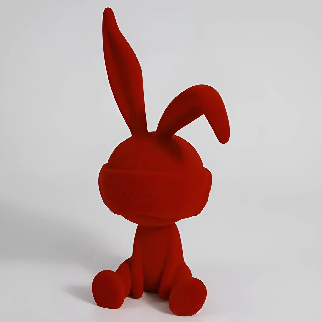 Green suede blindfold rabbit resin table ornament on a wooden surface.