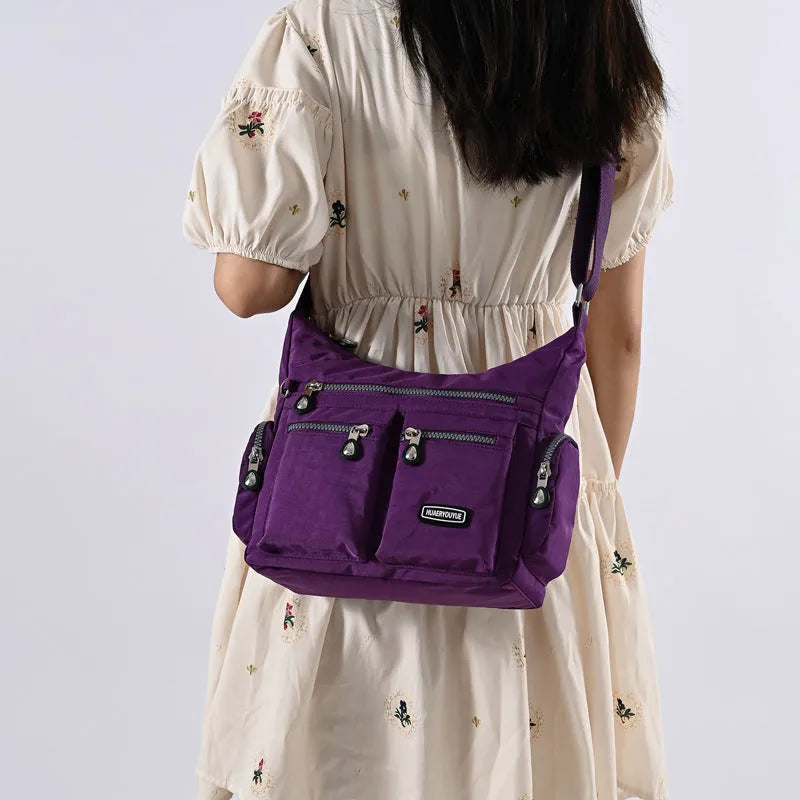 Women's waterproof nylon crossbody shoulder bag in black with multiple pockets and telescopic handle