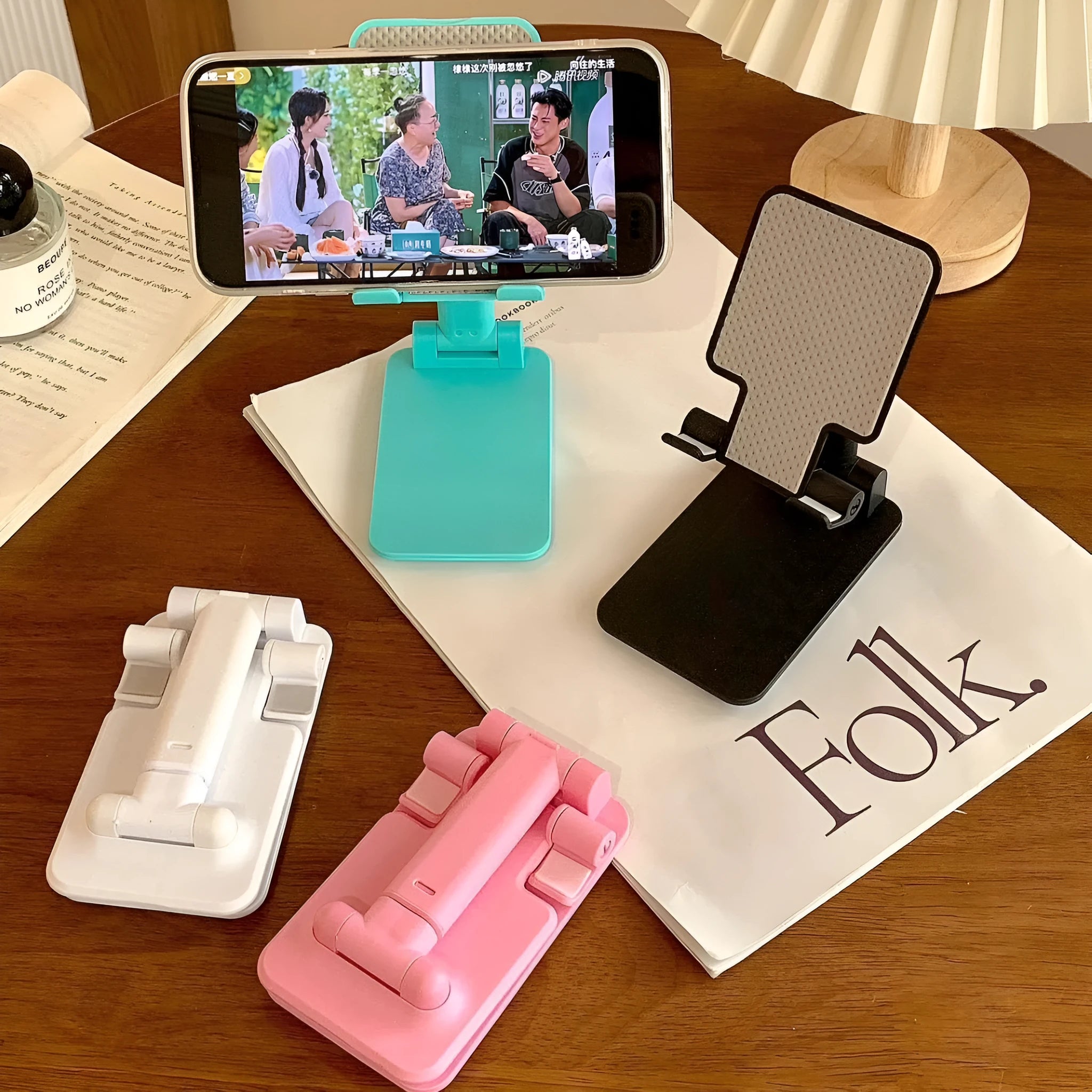 Folding plastic mobile phone stand in white, showing universal groove for hands-free viewing