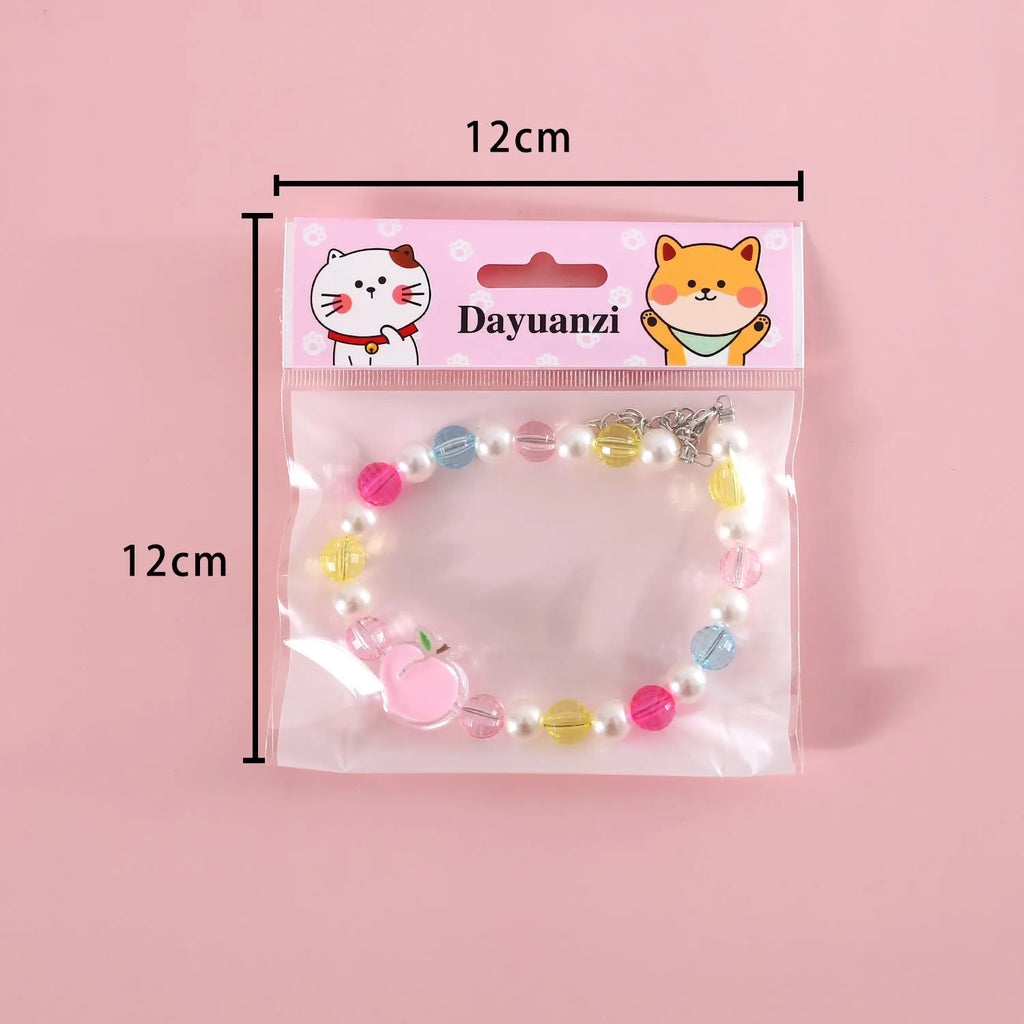 Colourful plastic bead pet necklace for cats in peach, rainbow, or small flower patterns on a white background.